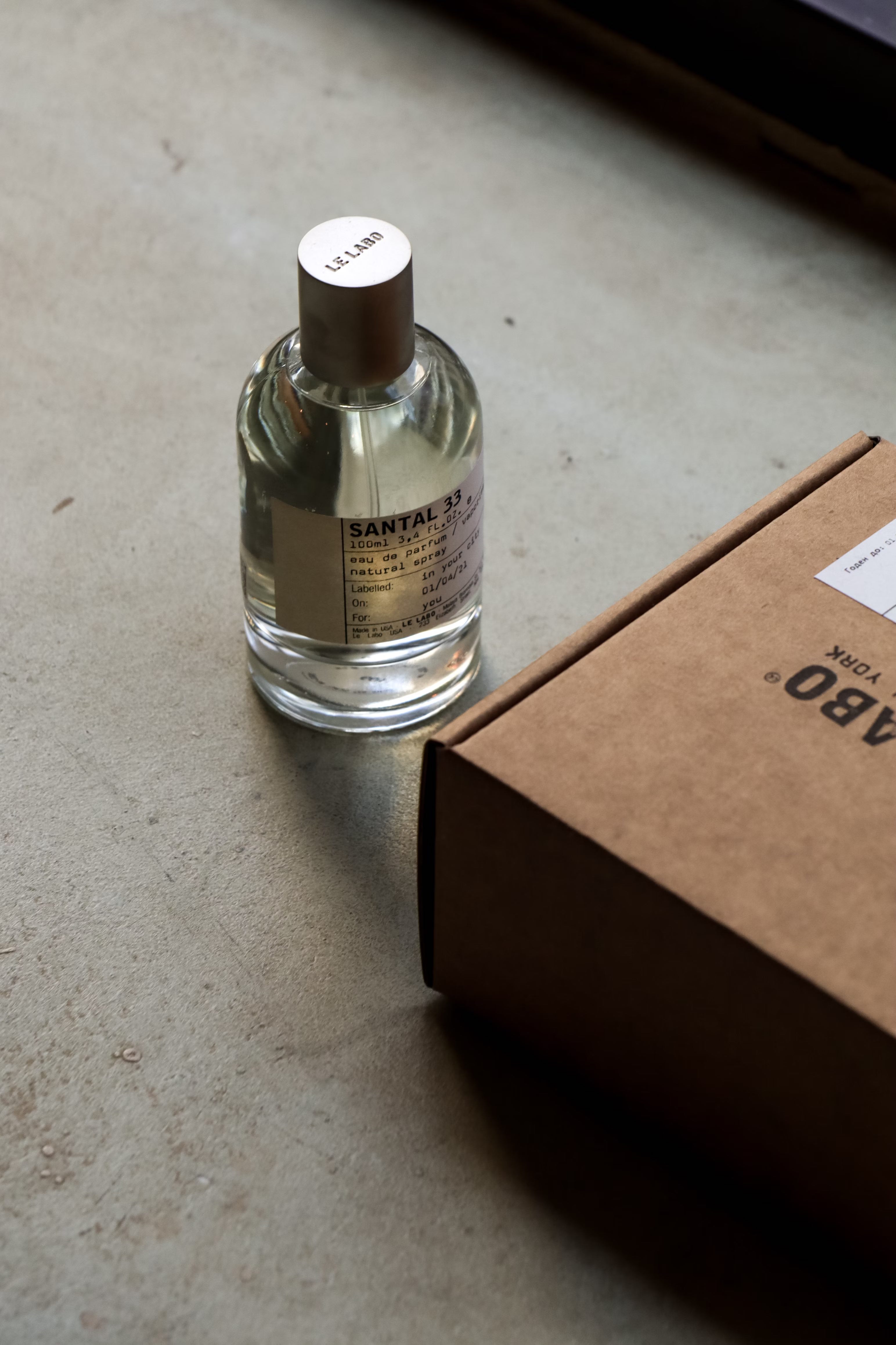 Le Labo Santal 33 perfume bottle next to packaging